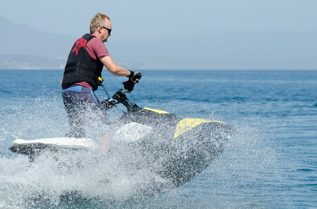 man-standing-up-while-driving-a-jet-ski-surrou
